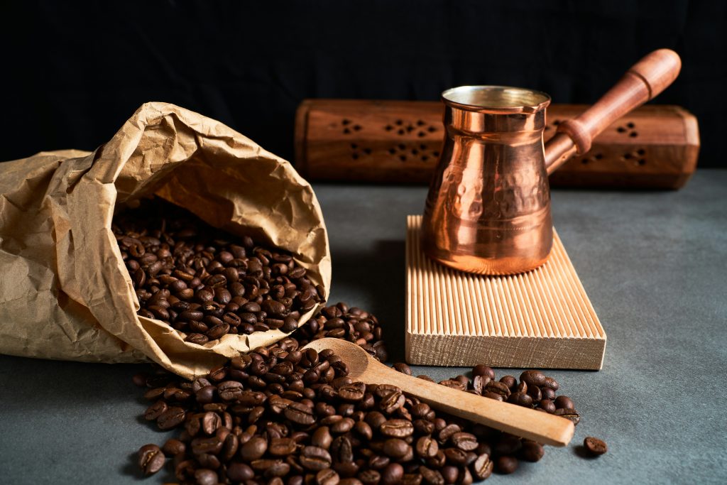 burplap bag of Turkish Coffee beans beside copper brewing vessel, photo by Ricardo Diaz